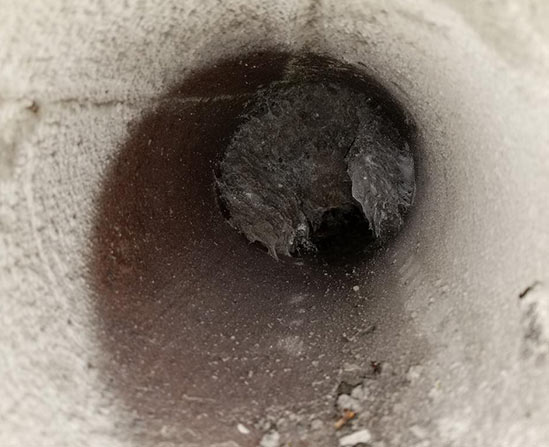 Video camera inspection view inside a sewer pipe showing a blockage